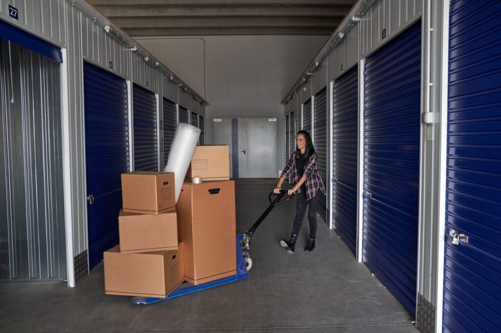 Woman rolling carton boxes into storage